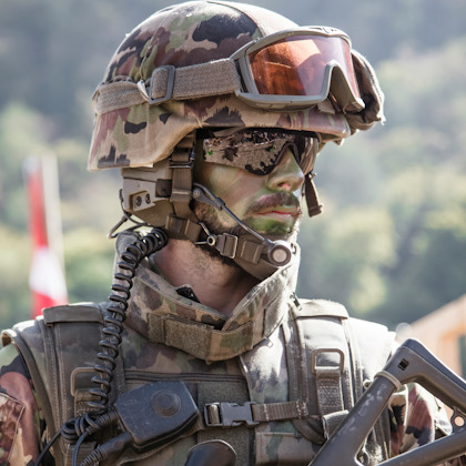 Militaire armé avec casque et masque, portant une tenue bariolée